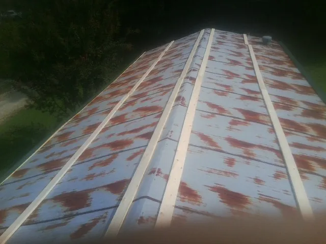 Rusted metal roof panels with new wood purlins before replacement — Storm Damage Roof Repair in North Adams by Roofing Brothers